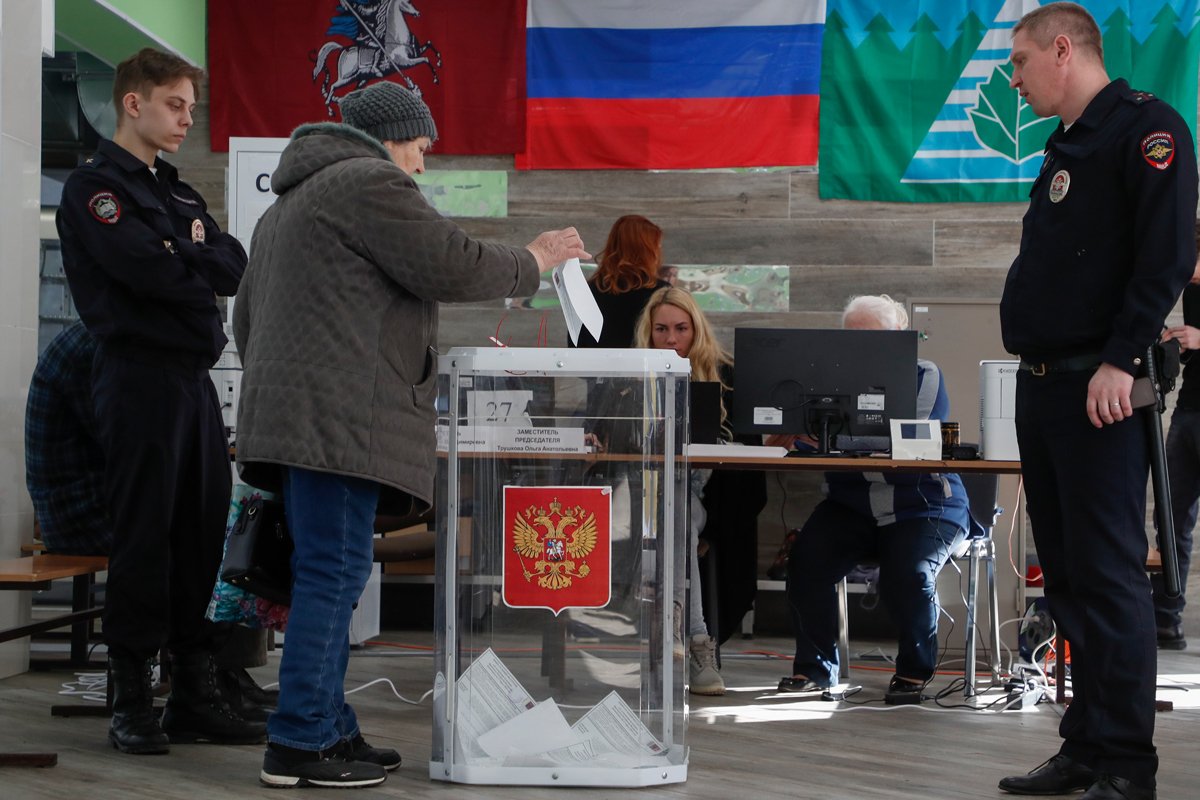 Голосование на избирательном участке под присмотром полицейских в Москве, 16 марта 2024 года. Фото: Максим Шипенков / EPA-EFE