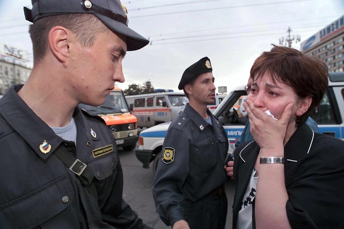 Женщина в слезах просит российского полицейского разрешить ей посетить место взрыва, чтобы проверить, нет ли родственников среди жертв в подземном переходе на Пушкинской площади, Москва, 8 августа 2000 года. Фото: EPA PHOTO/vk/kr