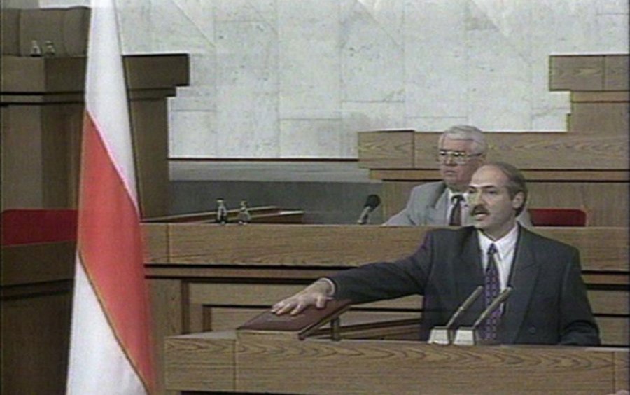 Александр Лукашенко дает присягу под бело-красно-белым флагом, 1994 год. Скриншот видеозаписи
