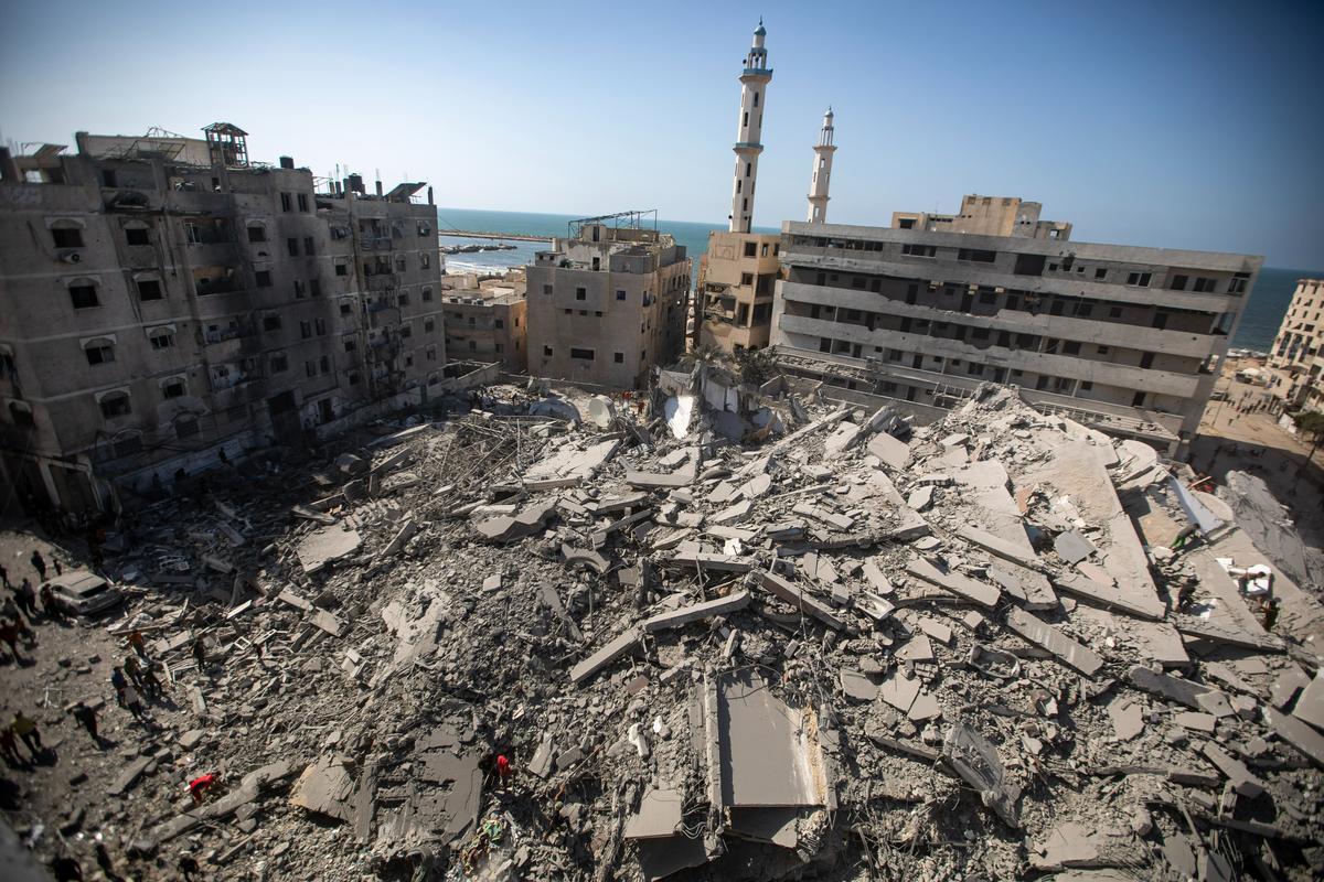 Палестинцы осматривают руины башни Аль-Гафари после израильского авиаудара в городе Газа, 15 сентября 2025 года. Фото: Haitham Imad / EPA