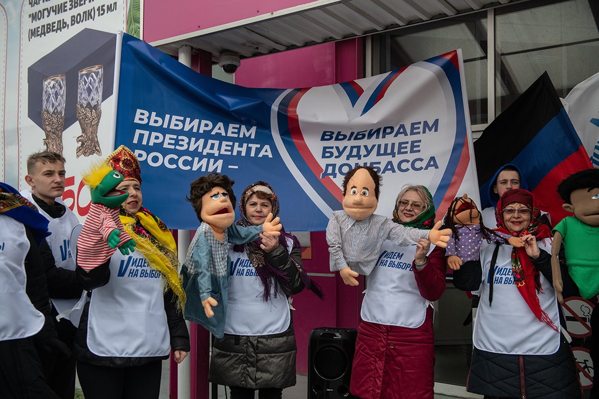 Волонтеры выступающие с куклами во время досрочного голосования на президентских выборах в России на улице в Донецке, контролируемой Россией части Украины, 13 марта 2024 года. Фото: Стрингер / EPA-EFE