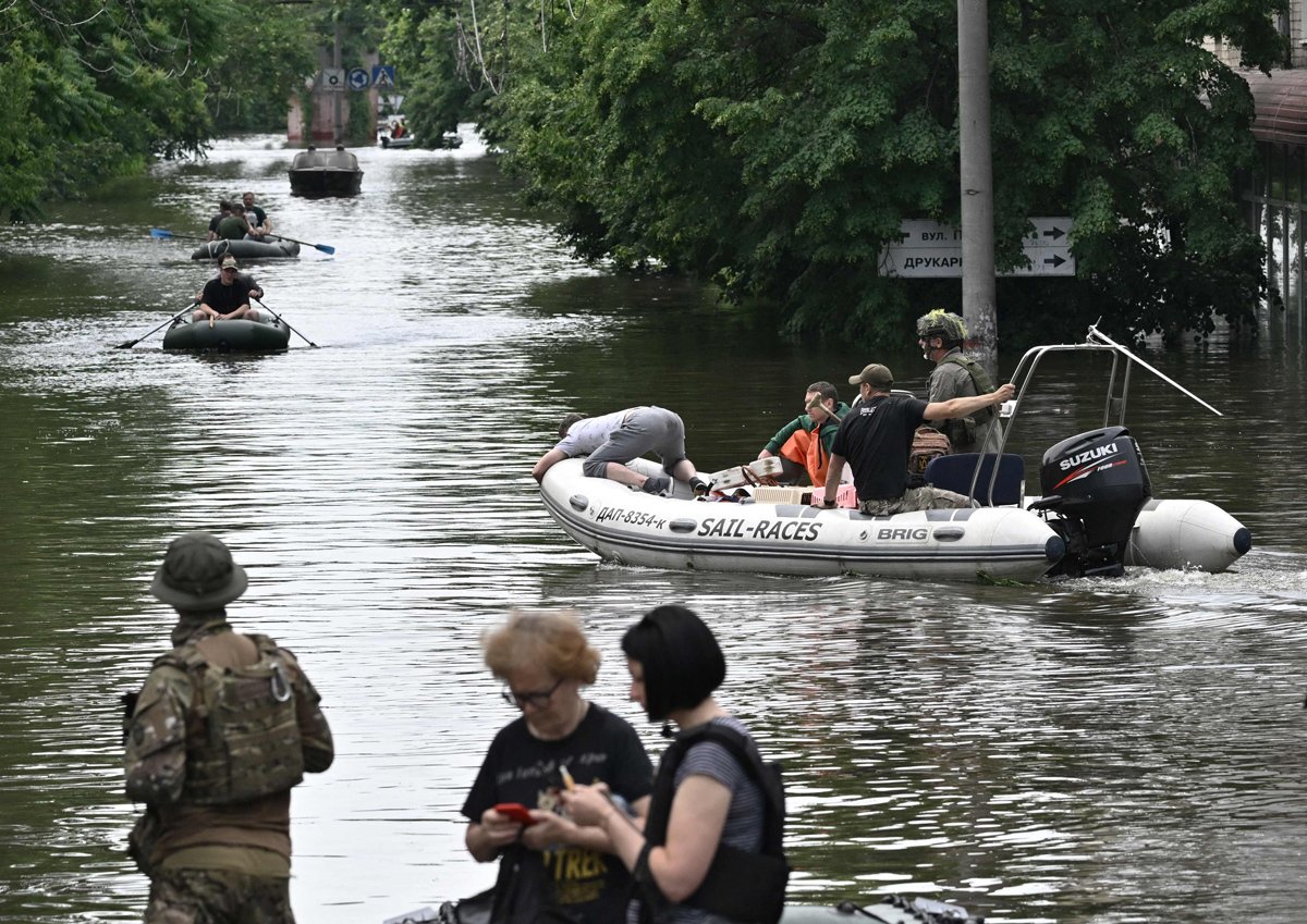 Украинские военнослужащие и волонтеры плывут на лодках во время эвакуации из зоны затопления в Херсоне 8 июня 2023 года. Фото: Genya Savilov / AFP / Scanpix / LETA