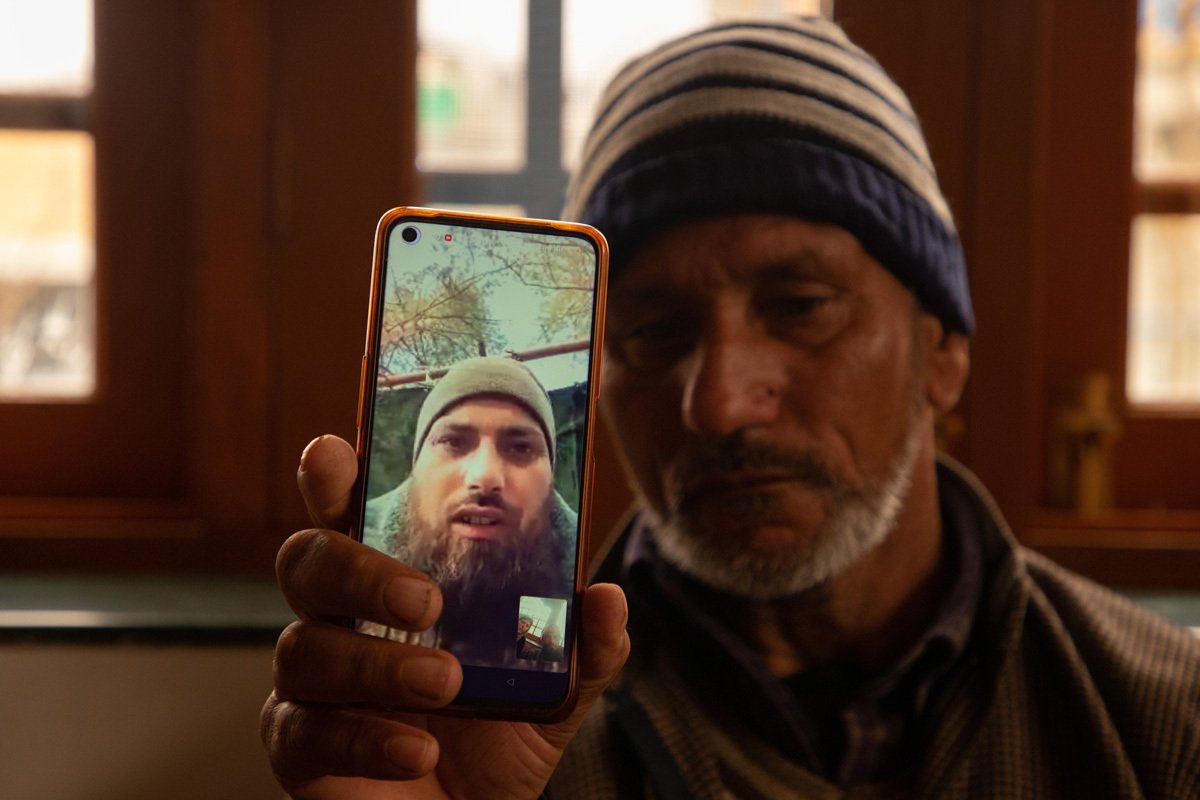 Отец Азада Юсуфа Кумара держит смартфон с фотографиями сына в военной форме, 28 февраля 2024 года. Фото: Faisal Bashir / SOPA Images / LightRocket / Getty Images