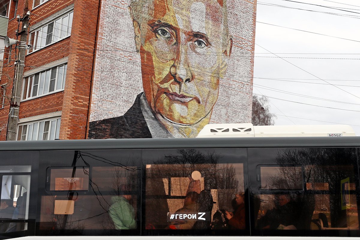 Автобус с хэштегом «#героиZ» проезжает по улице перед жилым домом с настенным изображением президента России Владимира Путина в городе Кашира, Россия, 20 апреля 2022 года. Фото: Максим Шипенков / EPA-EFE