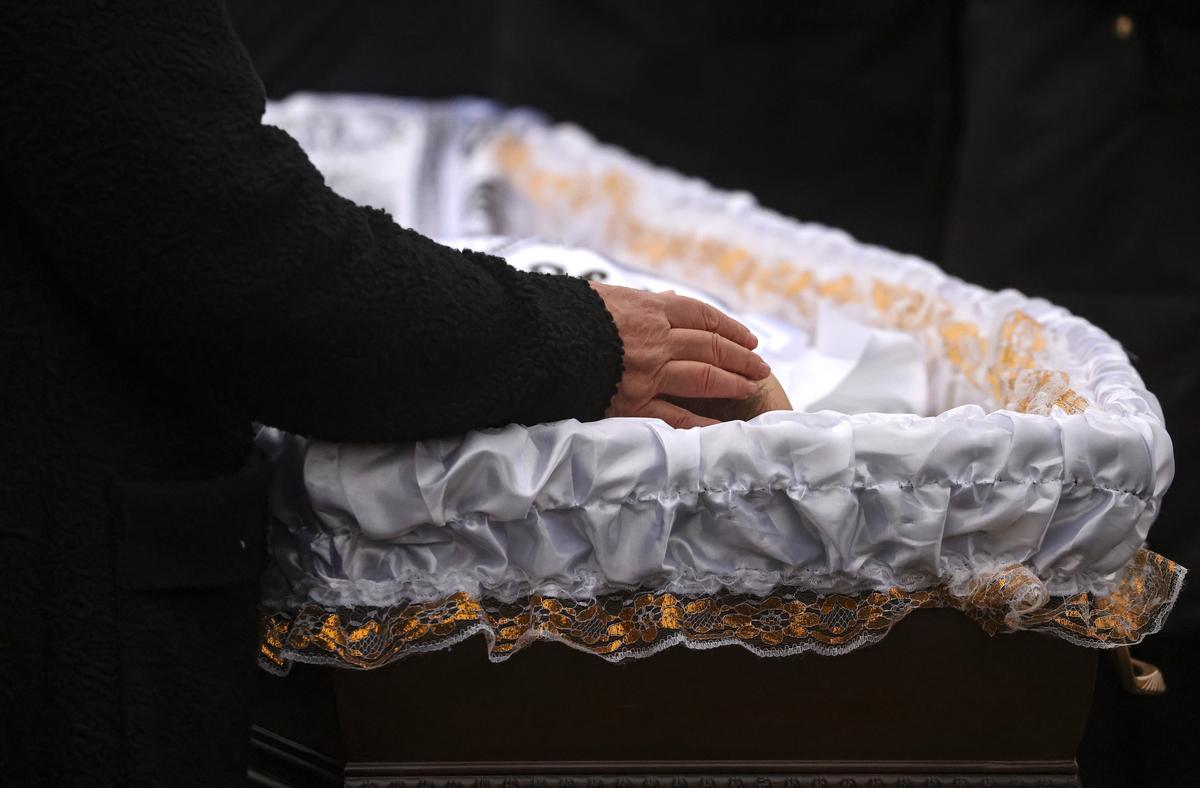 Alexey Navalny’s mother, Lyudmila Navalnaya, places her hand on her son's head at his funeral in Moscow, 1 March 2024. Photo: EPA-EFE/SERGEY ILNITSKY