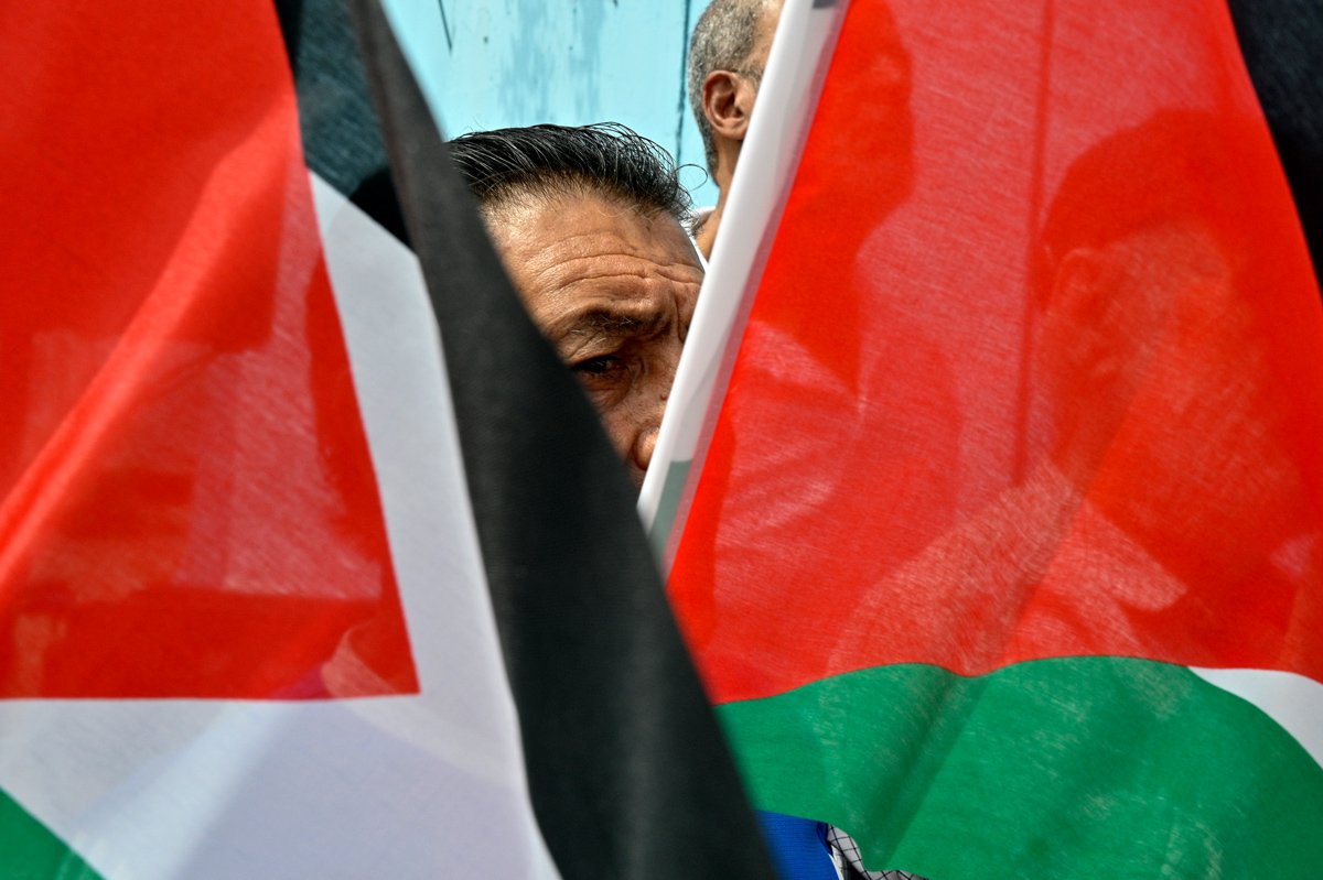 Палестинец несет флаги во время акции протеста в знак солидарности с Газой и БАПОР в Бейруте, Ливан, 28 мая 2024 года. Фото: Wael Hamzeh / EPA-EFE