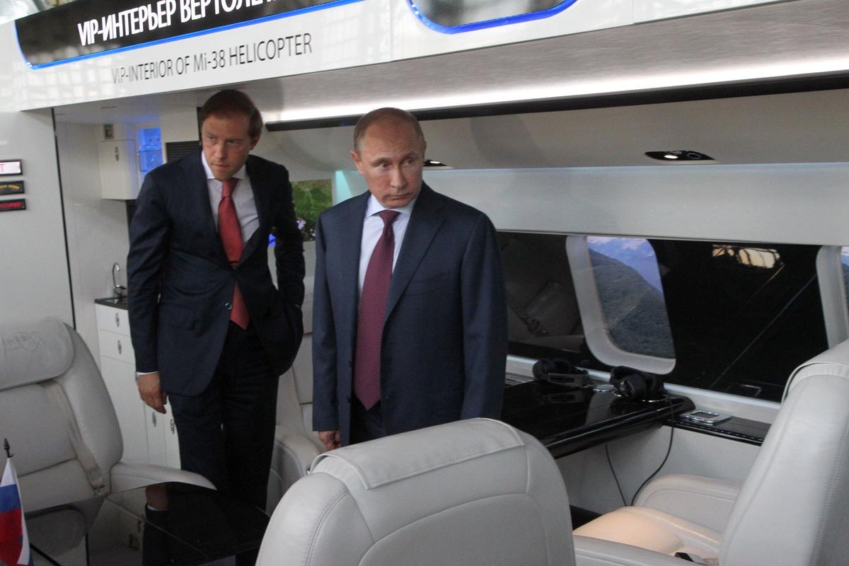 Denis Manturov and Vladimir Putin inspect the cabin of a new Mi-38 helicopter during a visit to a helicopter plant. Photo: Sasha Mordovets / Getty Images