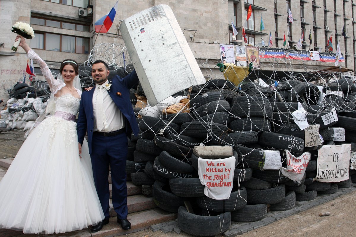 Пара в день свадьбы позирует на баррикадах в центре Донецка, 2 мая 2014 года. Фото: Игорь Коваленко / EPA