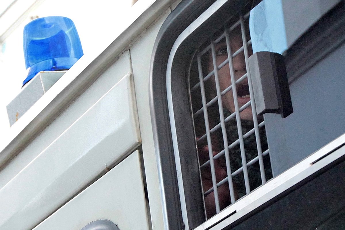 Оппозиционный активист в полицейском фургоне после задержания за плакат с надписью «Я против репрессий и пыток», Москва, Россия, 27 октября 2012 года. Фото: Максим Шипенков/EPA