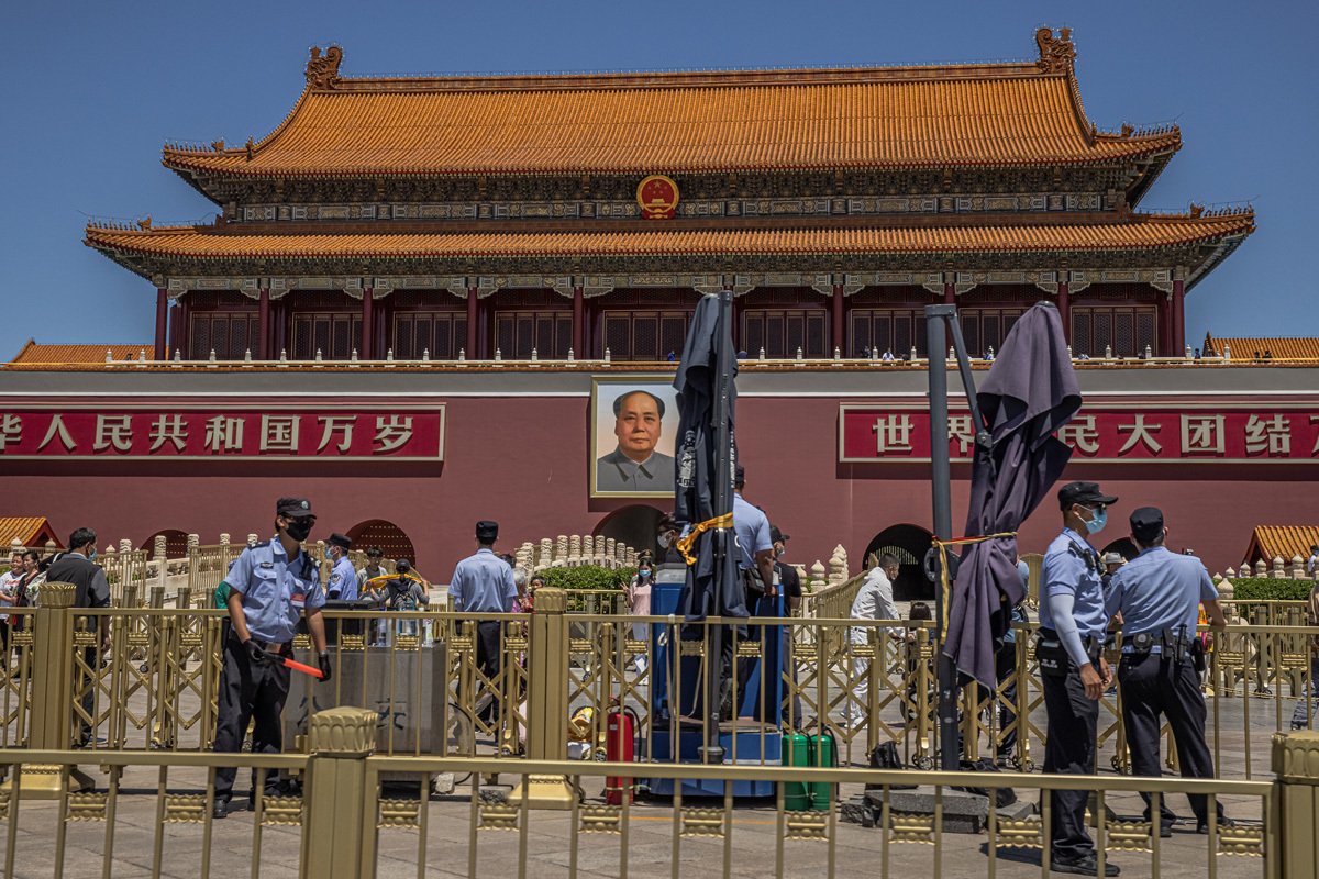 Китайские полицейские охраняют территорию рядом с портретом председателя Мао на южных воротах Запретного города перед площадью Тяньаньмэнь в день годовщины событий на площади Тяньаньмэнь 1989 года в Пекине, Китай, 4 июня 2021 года. Фото: Roman Pilipey / EPA-EFE