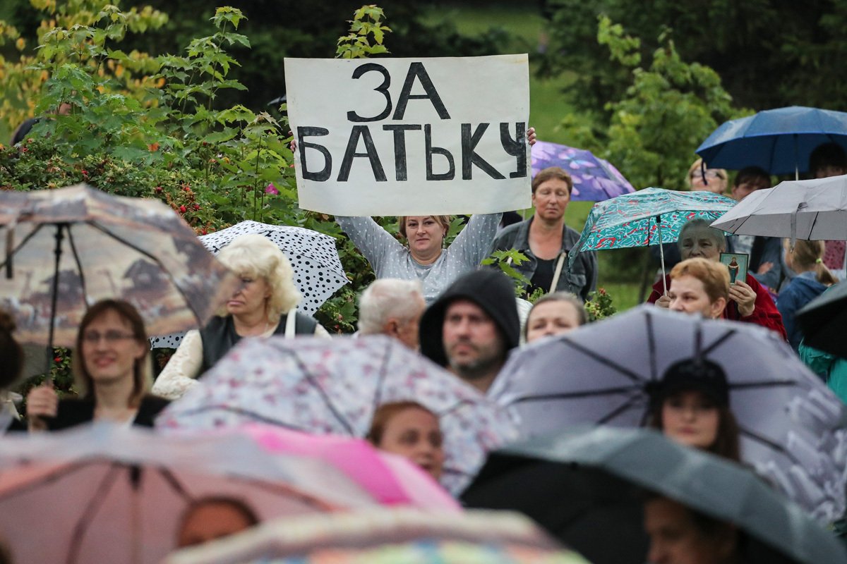 Сторонница Александра Лукашенко держит плакат с надписью «За батьку» во время митинга в центре Минска, Беларусь, 19 августа 2020 года. Фото: Татьяна Зенькович / EPA-EFE