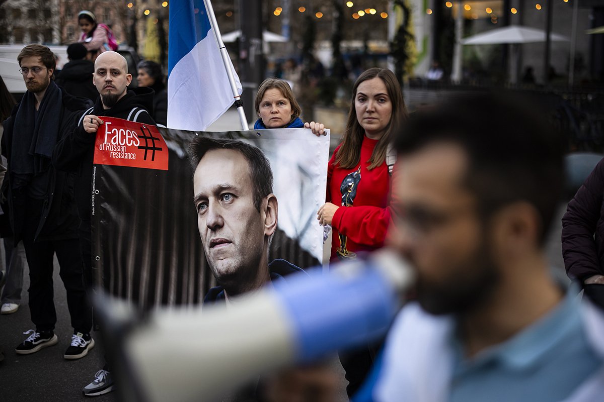 Люди держат плакат с портретом лидера российской оппозиции Алексея Навального во время акции протеста после его смерти в Цюрихе, Швейцария, 16 февраля 2024 года. Фото: Michael Buholzer / EPA-EFE