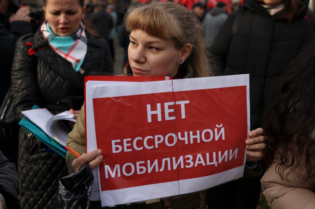 Участница митинга коммунистов в Москве держит плакат, выступая против бессрочной мобилизации, 7 ноября 2023 года. Фото: Сергей Ильницкий / EPA